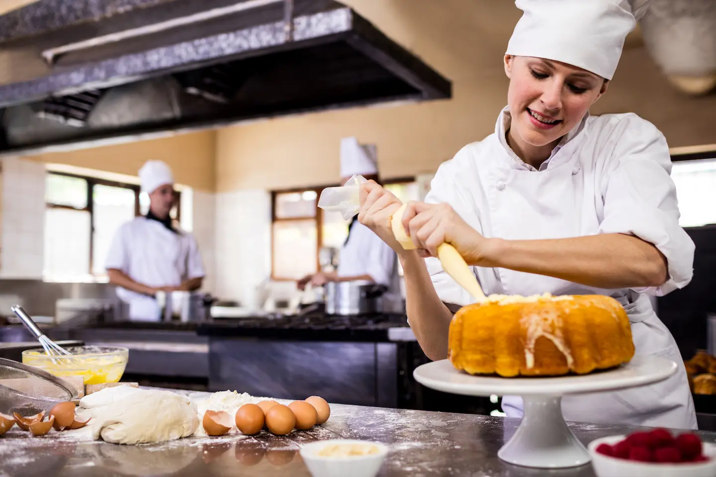 Female chef piping a cake in kitchen at hotel 2021 04 04 18 02 58 utc